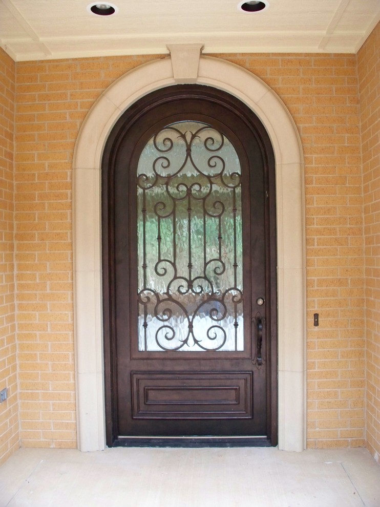 Ejemplo de puerta principal clásica de tamaño medio con paredes beige, suelo de cemento, puerta simple y puerta metalizada