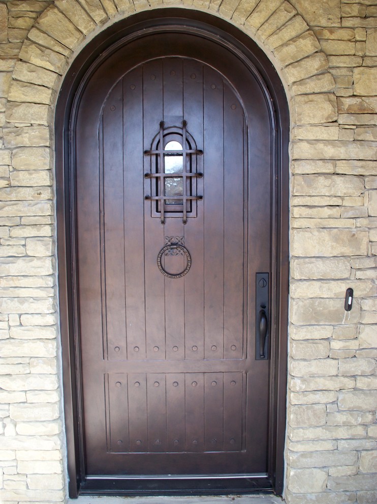 Réalisation d'une grande porte d'entrée tradition avec un mur beige, sol en béton ciré, une porte simple et une porte marron.