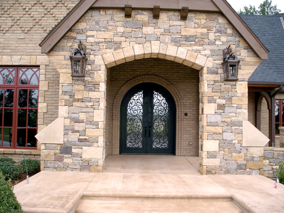 Exempel på en stor klassisk ingång och ytterdörr, med beige väggar, betonggolv, en dubbeldörr och metalldörr