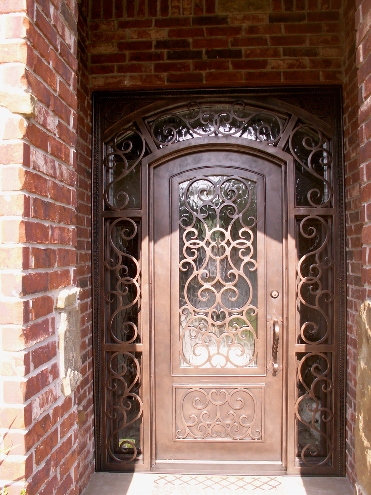 Ejemplo de puerta principal clásica de tamaño medio con paredes beige, suelo de cemento, puerta simple y puerta metalizada