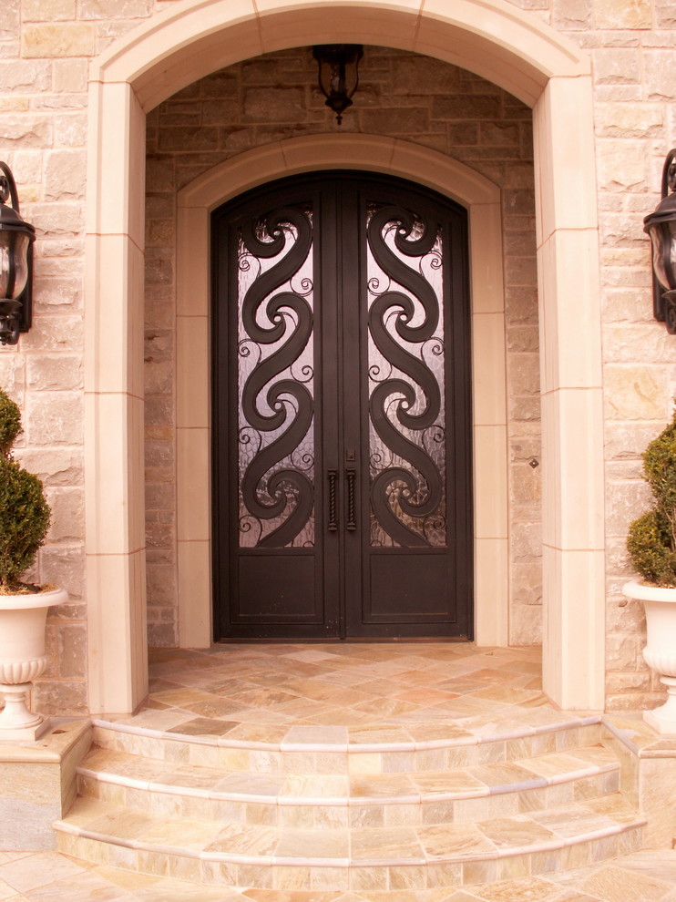 Imagen de puerta principal clásica grande con paredes beige, suelo de piedra caliza, puerta doble y puerta metalizada
