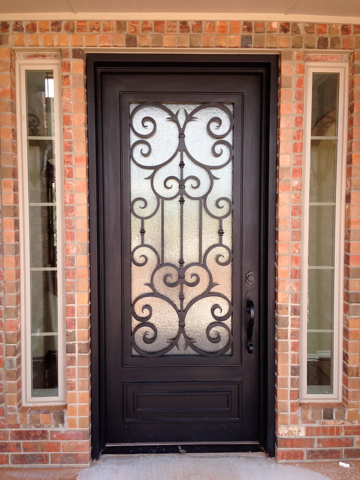 Imagen de puerta principal tradicional de tamaño medio con paredes beige, suelo de cemento, puerta simple y puerta metalizada