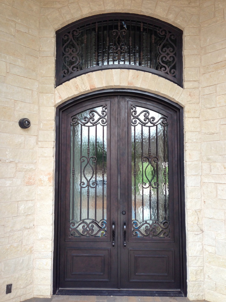 Imagen de puerta principal clásica grande con paredes beige, suelo de cemento, puerta doble y puerta metalizada