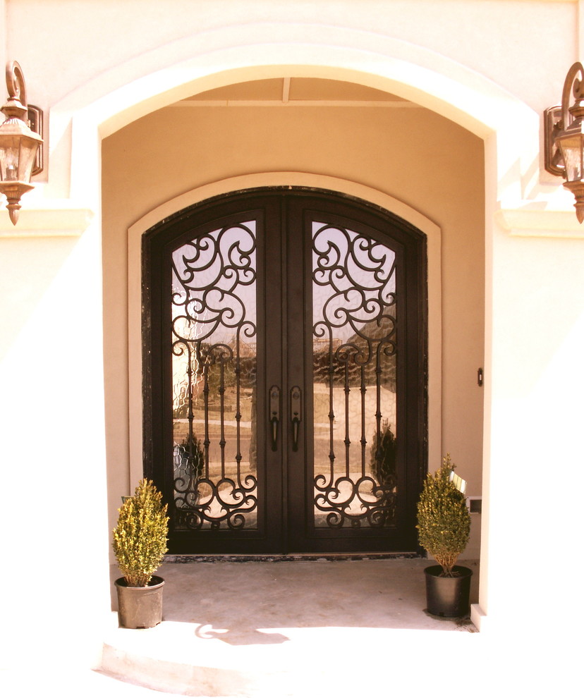 Aménagement d'une grande porte d'entrée classique avec un mur beige, sol en béton ciré, une porte double et une porte métallisée.