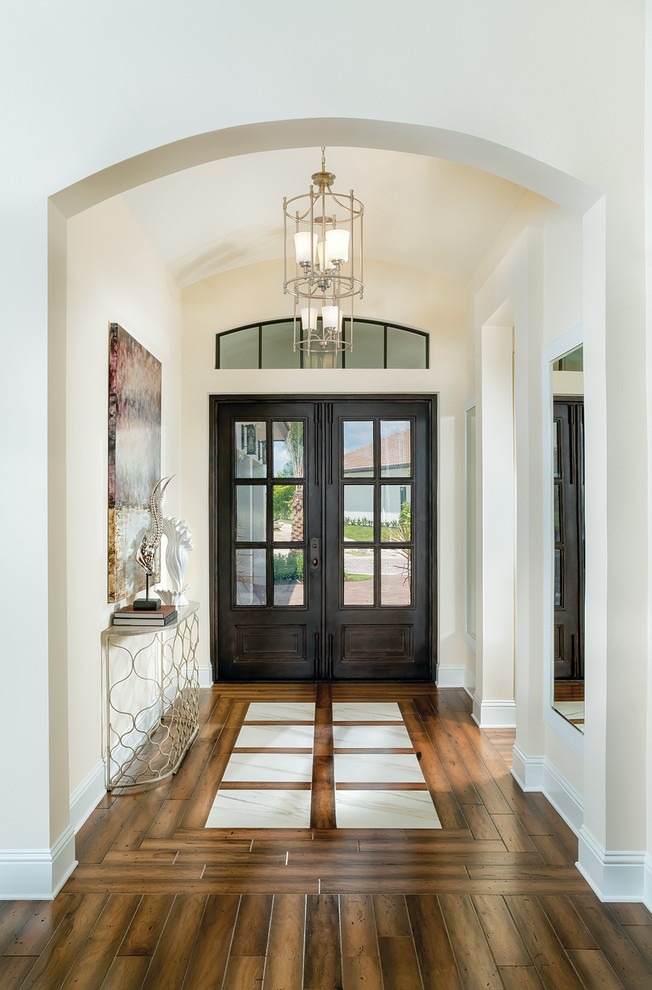Ispirazione per un ingresso minimal di medie dimensioni con pareti bianche, pavimento in legno massello medio, una porta a due ante e una porta in legno scuro
