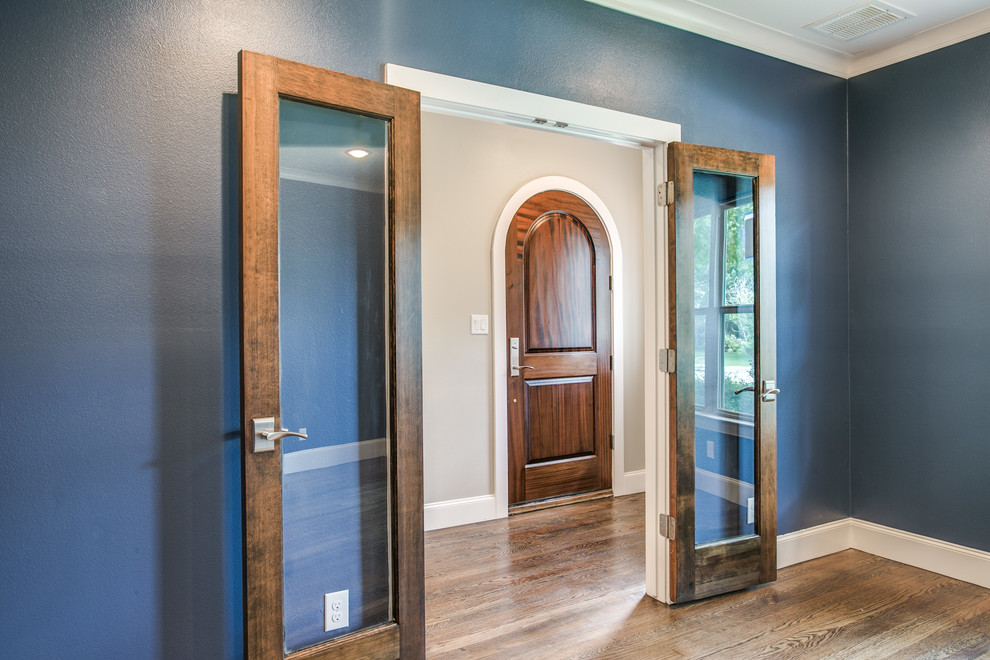 Ejemplo de puerta principal tradicional de tamaño medio con paredes azules, suelo de madera en tonos medios, puerta simple, puerta de madera en tonos medios y suelo marrón