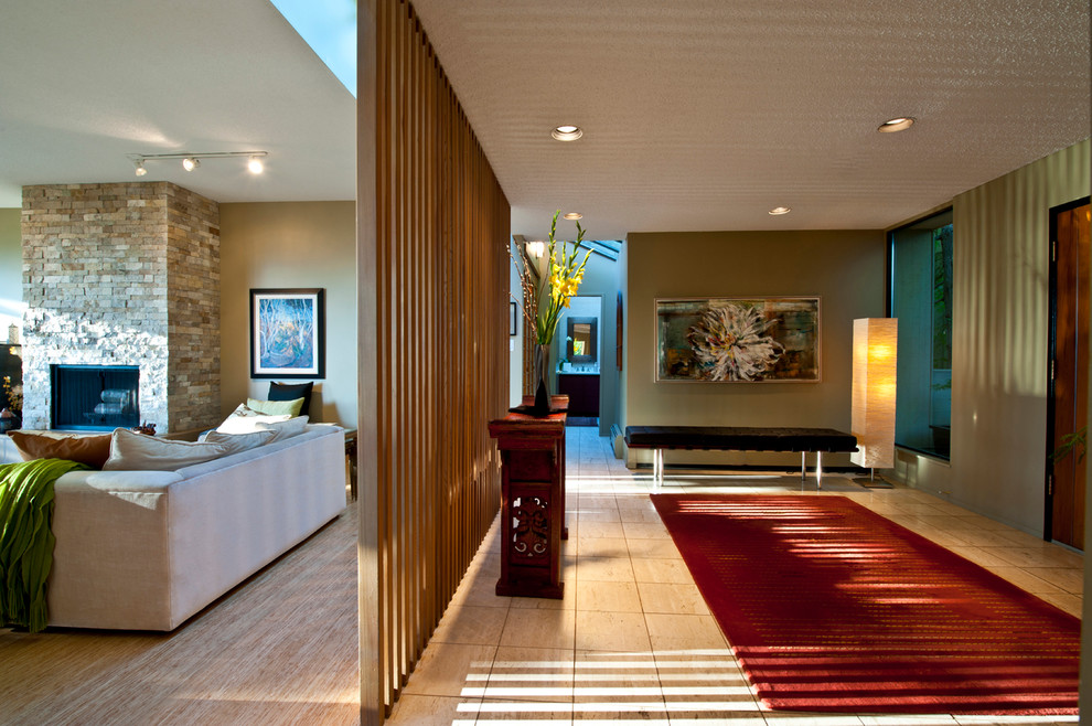 バンクーバーにある高級な広いモダンスタイルのおしゃれな玄関ロビー (緑の壁、トラバーチンの床、木目調のドア、ベージュの床) の写真