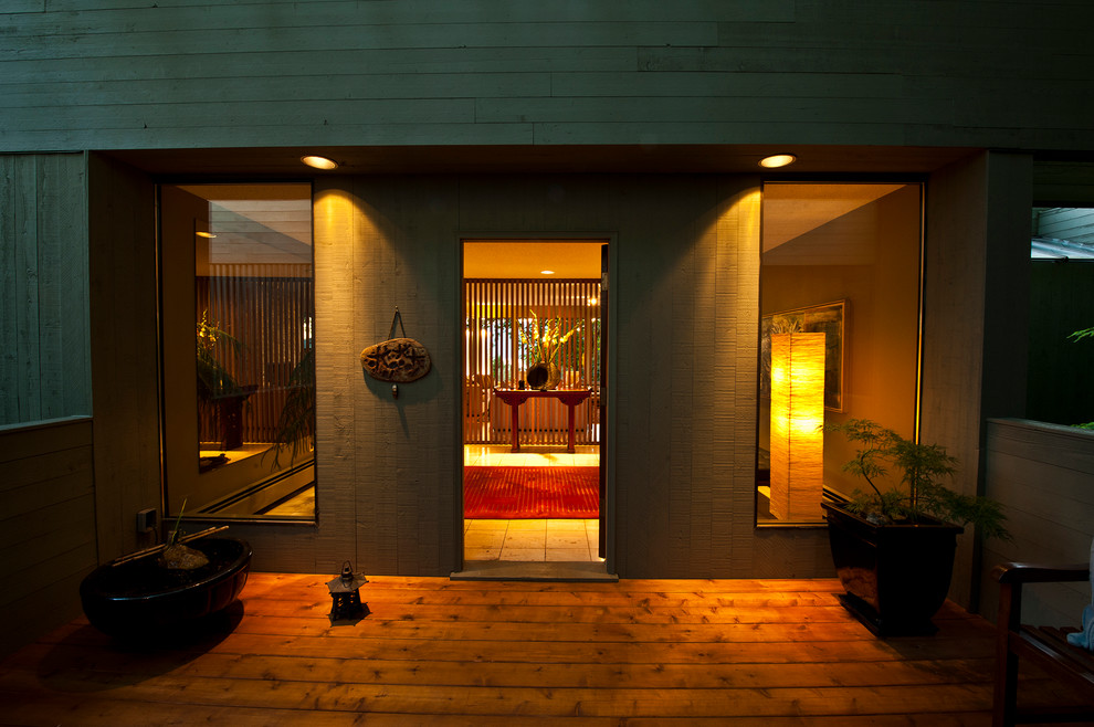 Стильный дизайн: большое фойе в стиле модернизм с зелеными стенами, полом из травертина, одностворчатой входной дверью и входной дверью из дерева среднего тона - последний тренд
