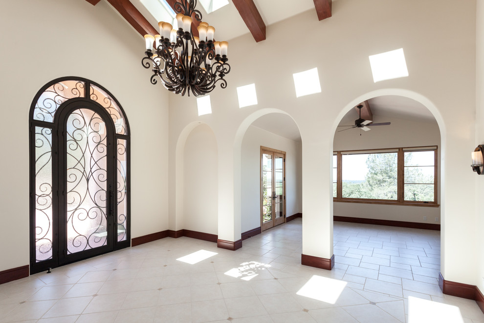 Стильный дизайн: большое фойе в средиземноморском стиле с белыми стенами, полом из керамической плитки, одностворчатой входной дверью и стеклянной входной дверью - последний тренд