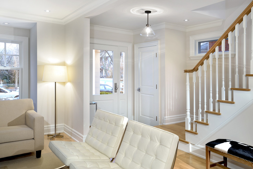 Kleines Klassisches Foyer mit weißer Wandfarbe, hellem Holzboden, Einzeltür und weißer Haustür in Toronto
