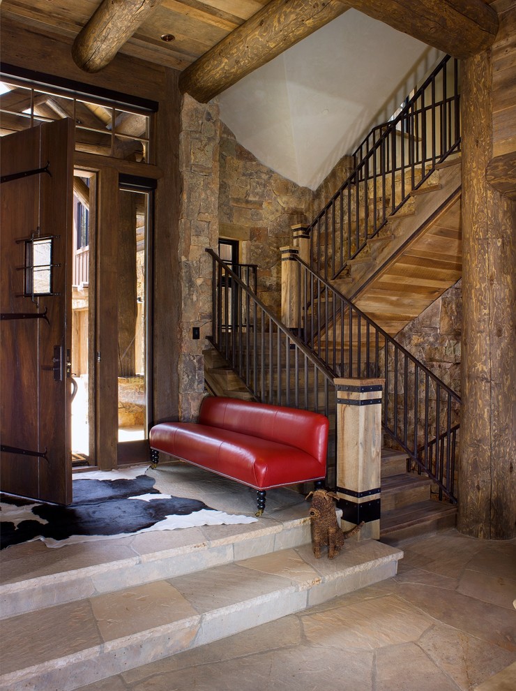 Example of a mountain style entryway design in Denver with a dark wood front door