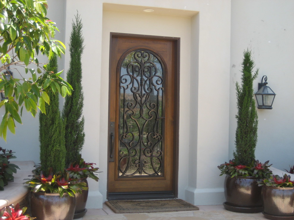 Imagen de puerta principal rural de tamaño medio con paredes blancas, puerta simple y puerta de madera en tonos medios