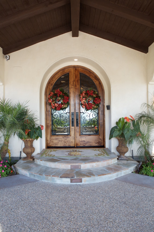 Diseño de puerta principal mediterránea de tamaño medio con paredes blancas, puerta doble y puerta de madera en tonos medios