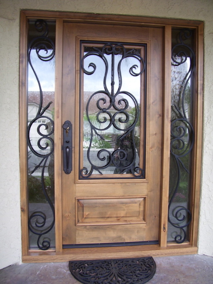 Imagen de puerta principal mediterránea de tamaño medio con paredes blancas, puerta simple y puerta de madera en tonos medios