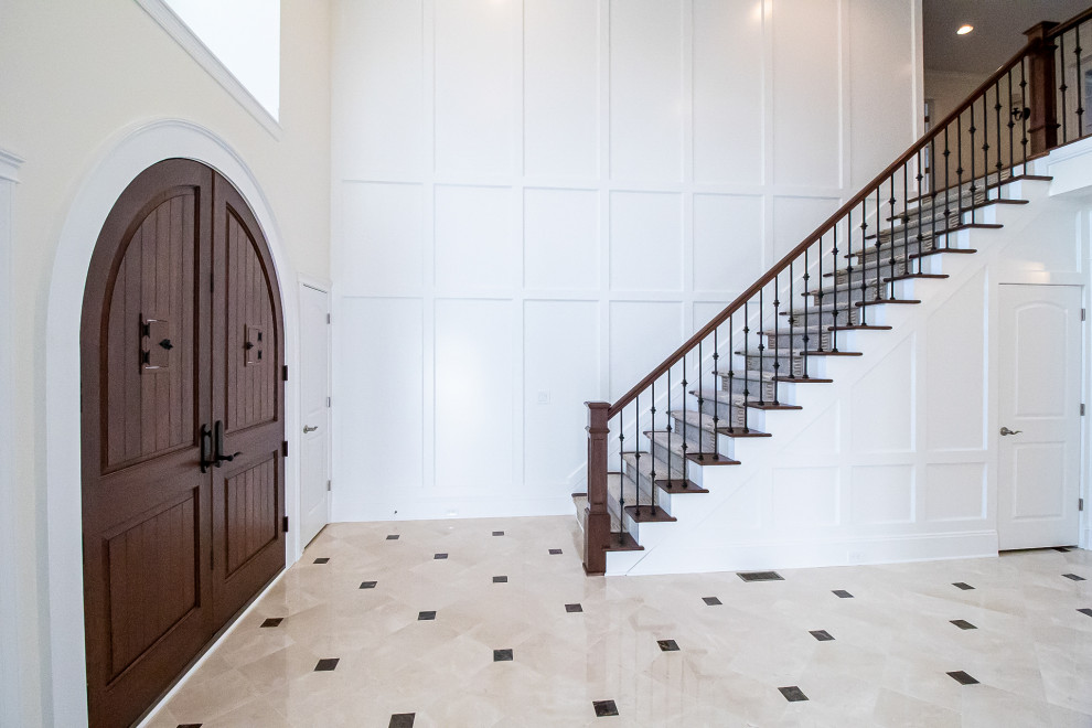 クリーブランドにあるラグジュアリーな巨大なシャビーシック調のおしゃれな玄関ロビー (白い壁、濃色木目調のドア、マルチカラーの床) の写真