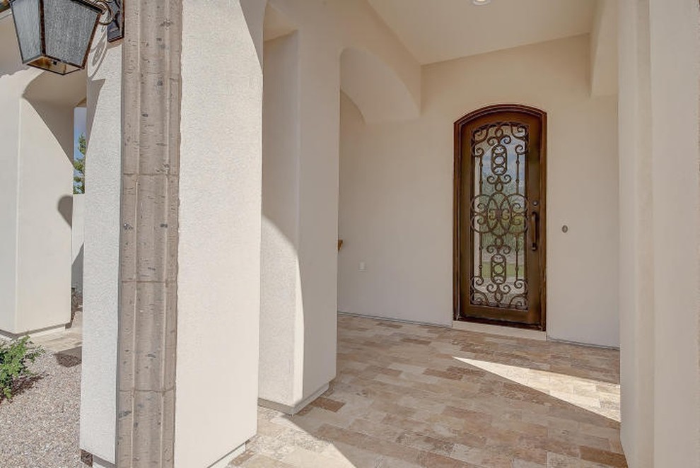 Large mediterranean front door in Phoenix with beige walls, travertine flooring, a single front door, a brown front door and beige floors.