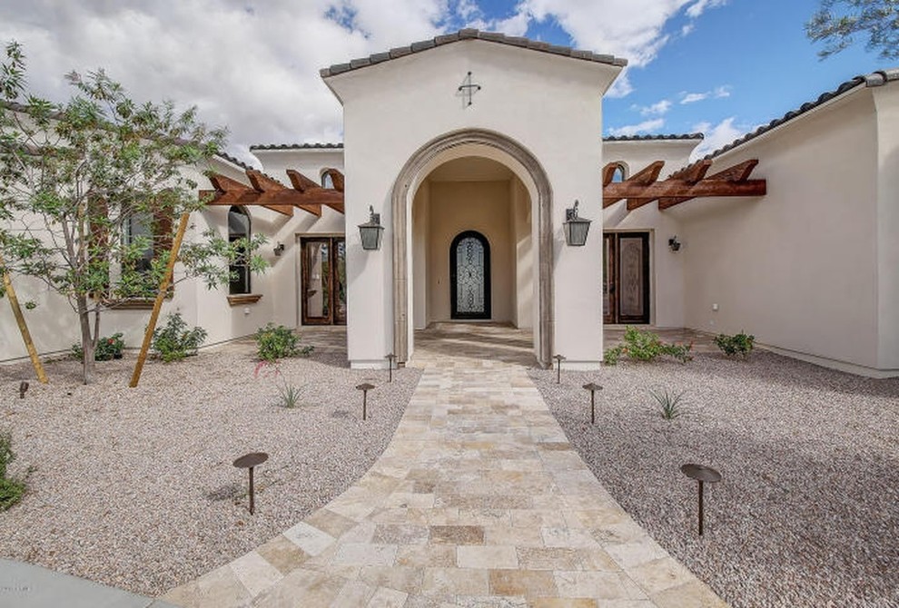 Große Mediterrane Haustür mit beiger Wandfarbe, Travertin, Einzeltür, brauner Haustür und beigem Boden in Phoenix