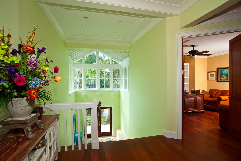 Idée de décoration pour un grand hall d'entrée ethnique avec un mur vert, parquet foncé, une porte double et une porte en verre.