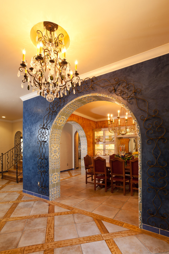 Idee per un ingresso bohémian con pareti blu, pavimento in travertino, una porta singola e una porta in legno bruno