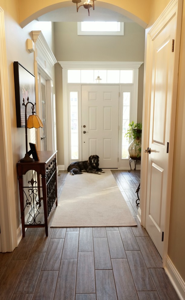 Свежая идея для дизайна: фойе среднего размера в классическом стиле с серыми стенами, полом из керамогранита, одностворчатой входной дверью, белой входной дверью и коричневым полом - отличное фото интерьера