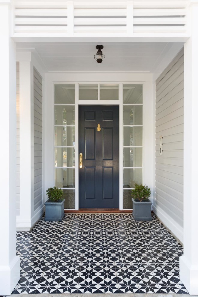 Inredning av en klassisk mellanstor ingång och ytterdörr, med grå väggar, klinkergolv i porslin, en enkeldörr, en blå dörr och flerfärgat golv