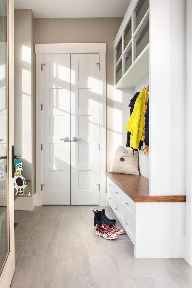 Example of a mid-sized transitional porcelain tile mudroom design in Calgary with beige walls
