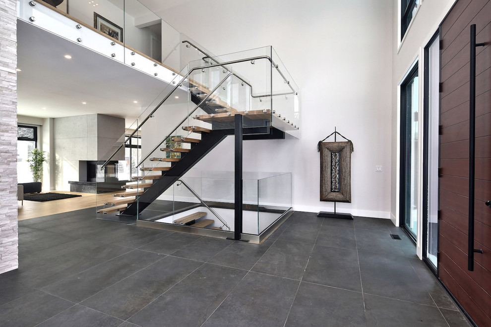 Großes Modernes Foyer mit grauer Wandfarbe, braunem Holzboden, Einzeltür, hellbrauner Holzhaustür und schwarzem Boden in Toronto