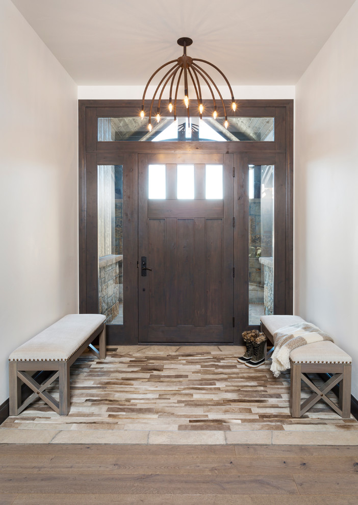 Entryway - mid-sized traditional travertine floor and beige floor entryway idea in Denver with white walls and a dark wood front door