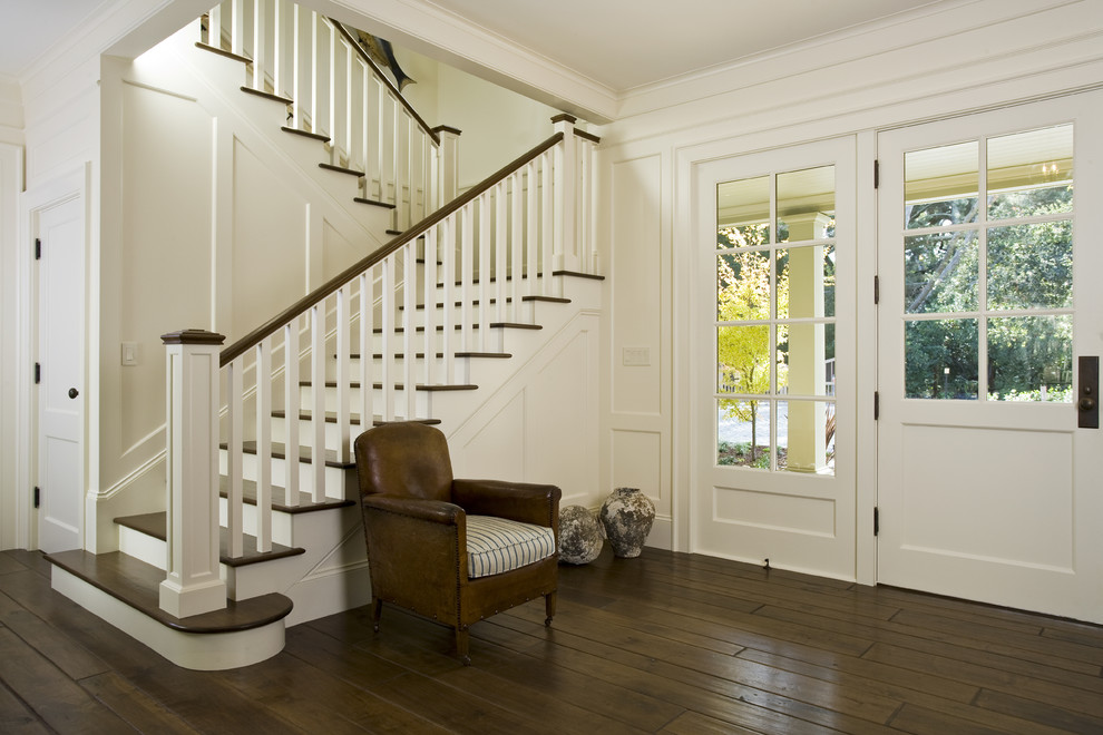 Пример оригинального дизайна: фойе в классическом стиле с белыми стенами, темным паркетным полом, одностворчатой входной дверью, белой входной дверью и коричневым полом