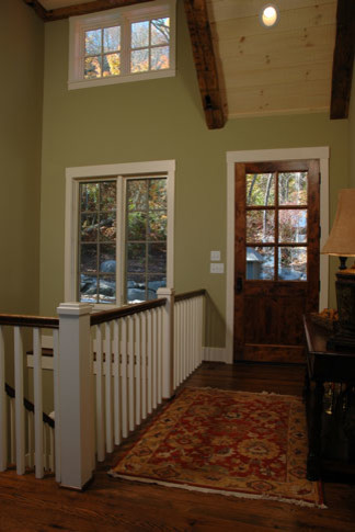 Entryway - large rustic medium tone wood floor entryway idea in Other with green walls and a medium wood front door