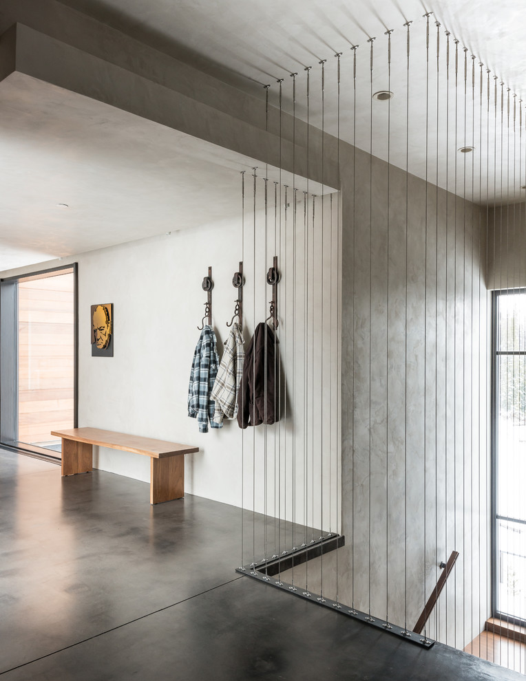 На фото: узкая прихожая среднего размера в стиле модернизм с серыми стенами и бетонным полом с