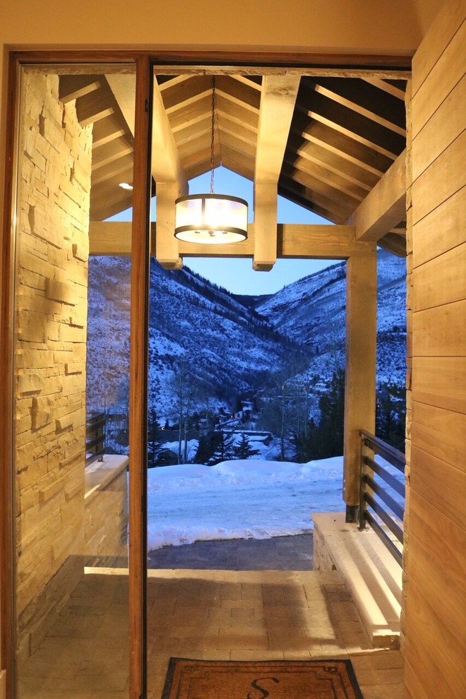 Large mountain style entryway photo in Denver with a medium wood front door