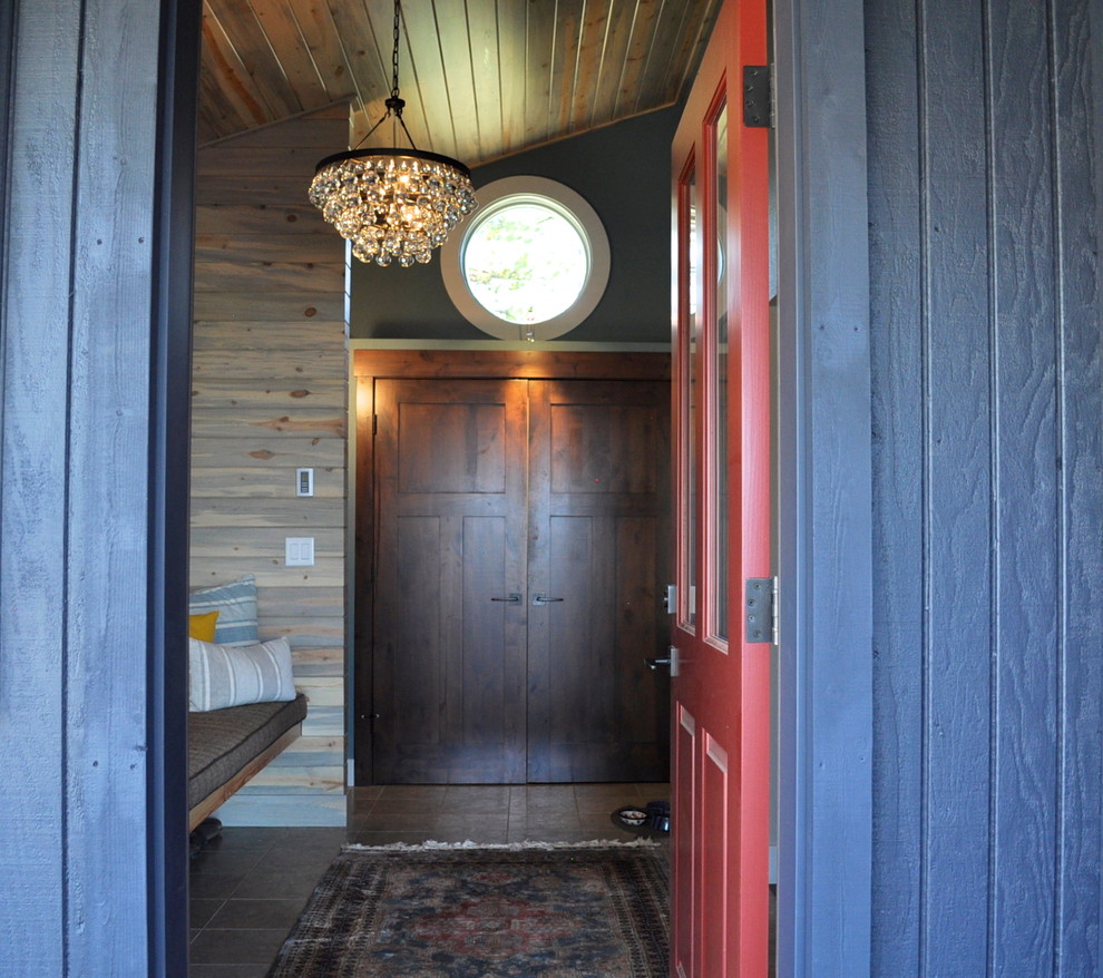 Réalisation d'une porte d'entrée bohème de taille moyenne avec un mur gris, un sol en carrelage de porcelaine, une porte simple, une porte rouge et un sol marron.