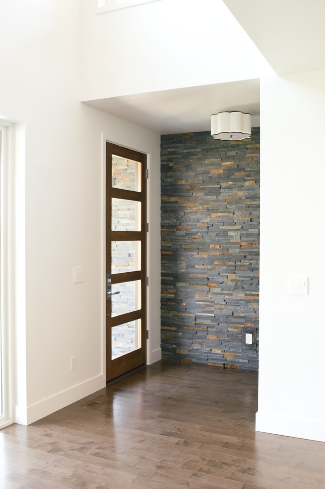 Modelo de puerta principal moderna de tamaño medio con paredes blancas, suelo de madera en tonos medios, puerta simple y puerta de madera en tonos medios