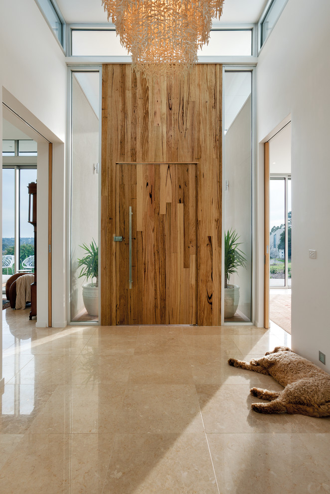 Imagen de entrada rústica de tamaño medio con paredes blancas, puerta simple, puerta de madera en tonos medios y suelo de travertino