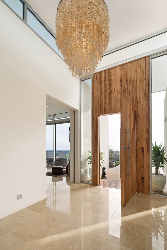 Diseño de entrada contemporánea de tamaño medio con paredes blancas, puerta simple y puerta de madera en tonos medios