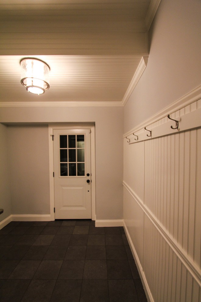 Стильный дизайн: узкая прихожая среднего размера в стиле кантри с серыми стенами, одностворчатой входной дверью, белой входной дверью и полом из сланца - последний тренд