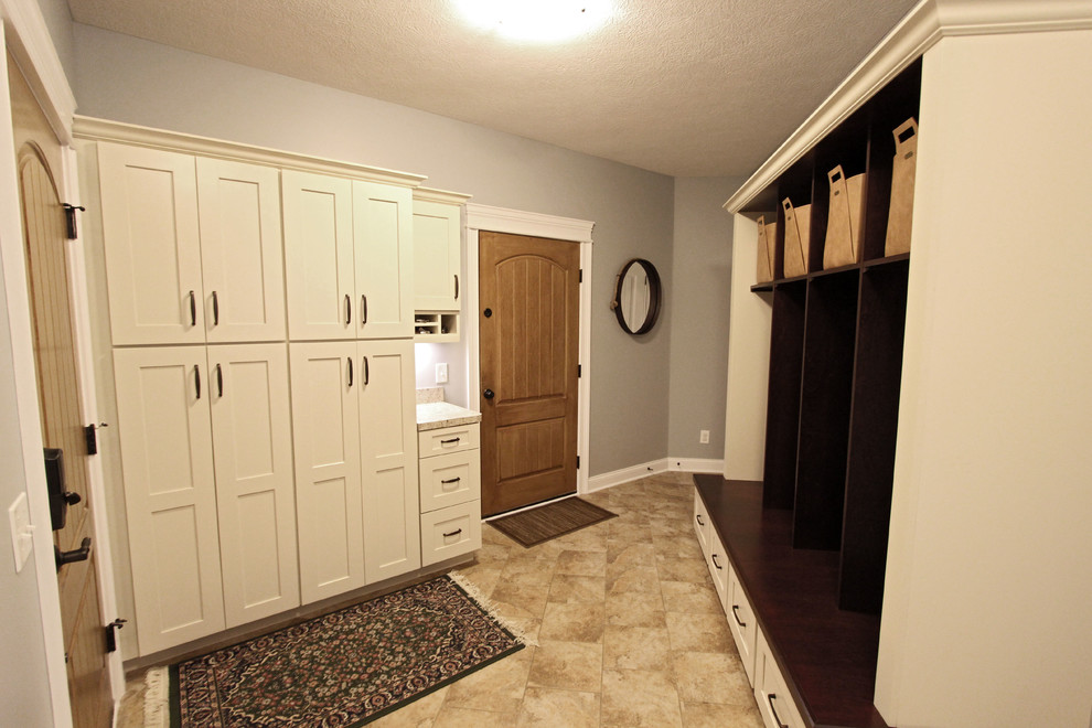 This is an example of a medium sized traditional boot room in Cleveland with grey walls, ceramic flooring, a single front door, a medium wood front door and beige floors.