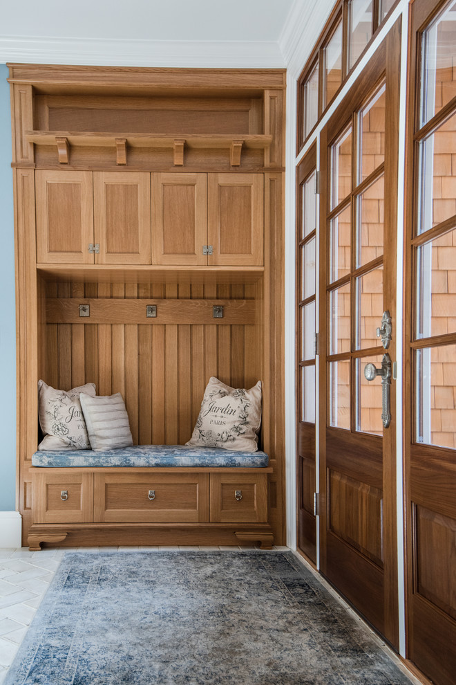 Idées déco pour une entrée classique avec un vestiaire, un mur bleu, une porte simple et une porte en bois foncé.