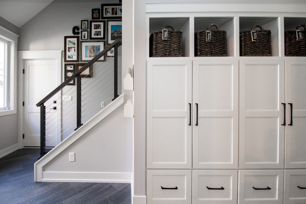 Idée de décoration pour une entrée craftsman avec un vestiaire, un mur gris, un sol en carrelage de céramique, une porte simple, une porte blanche et un sol gris.