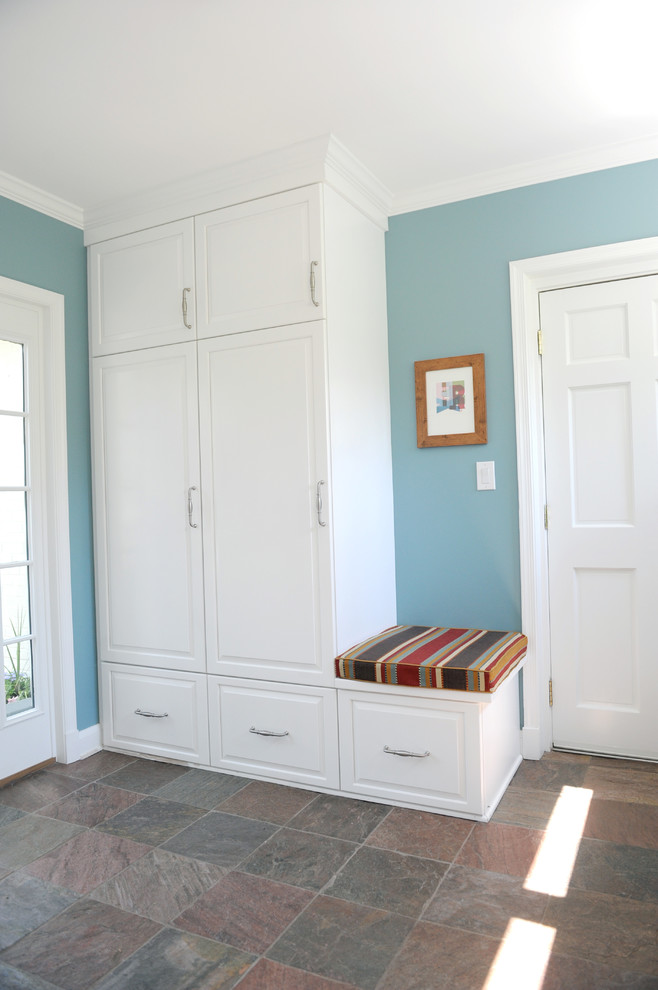 Aménagement d'une petite entrée classique avec un vestiaire, un mur bleu et un sol en ardoise.