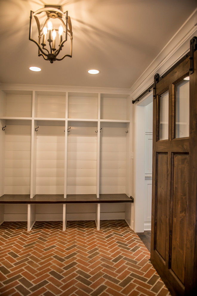 Mid-sized country brick floor mudroom photo in Kansas City with white walls