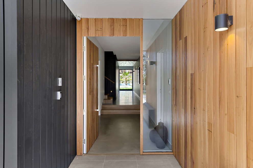 Idées déco pour une porte d'entrée contemporaine de taille moyenne avec un mur gris, sol en béton ciré, une porte simple, une porte en bois brun et un sol gris.