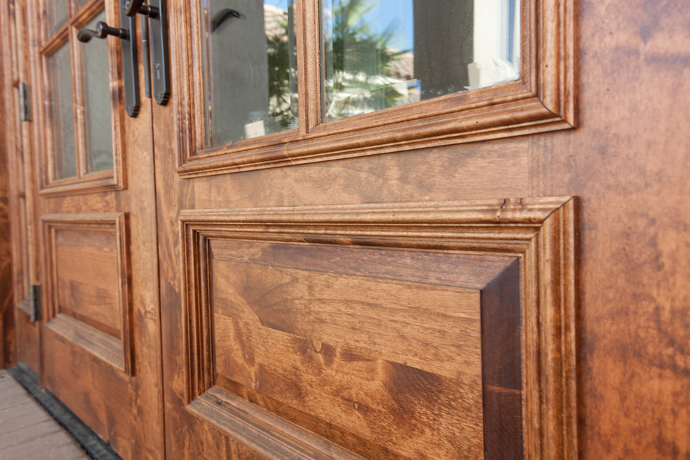 Modelo de puerta principal tradicional de tamaño medio con paredes beige, puerta doble y puerta de madera en tonos medios