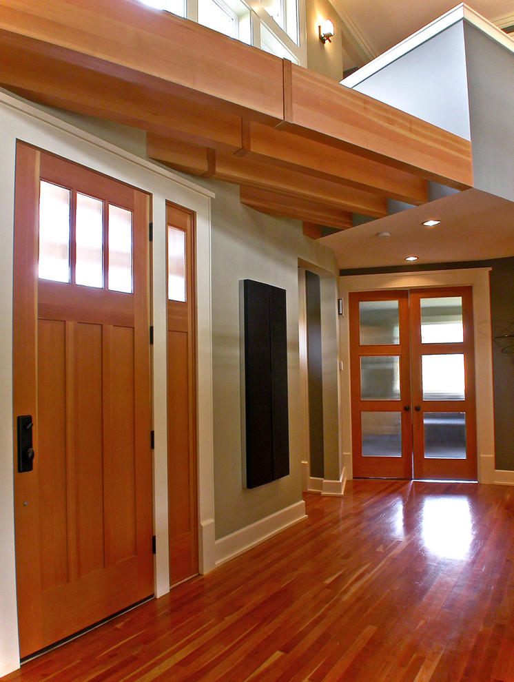 Cette image montre une entrée design avec une porte simple et une porte en bois brun.