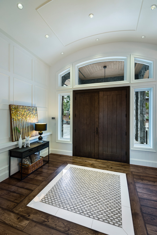 Inspiration for an expansive classic foyer in Vancouver with white walls, medium hardwood flooring, a double front door, a dark wood front door, brown floors and feature lighting.