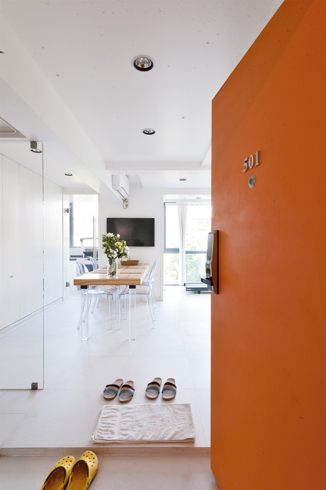他の地域にあるお手頃価格の中くらいなコンテンポラリースタイルのおしゃれな玄関ロビー (白い壁、セラミックタイルの床、オレンジのドア) の写真