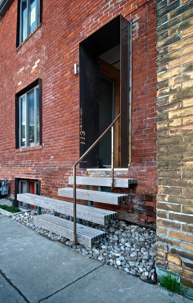 Inspiration for an industrial entrance in Toronto with a single front door and a black front door.