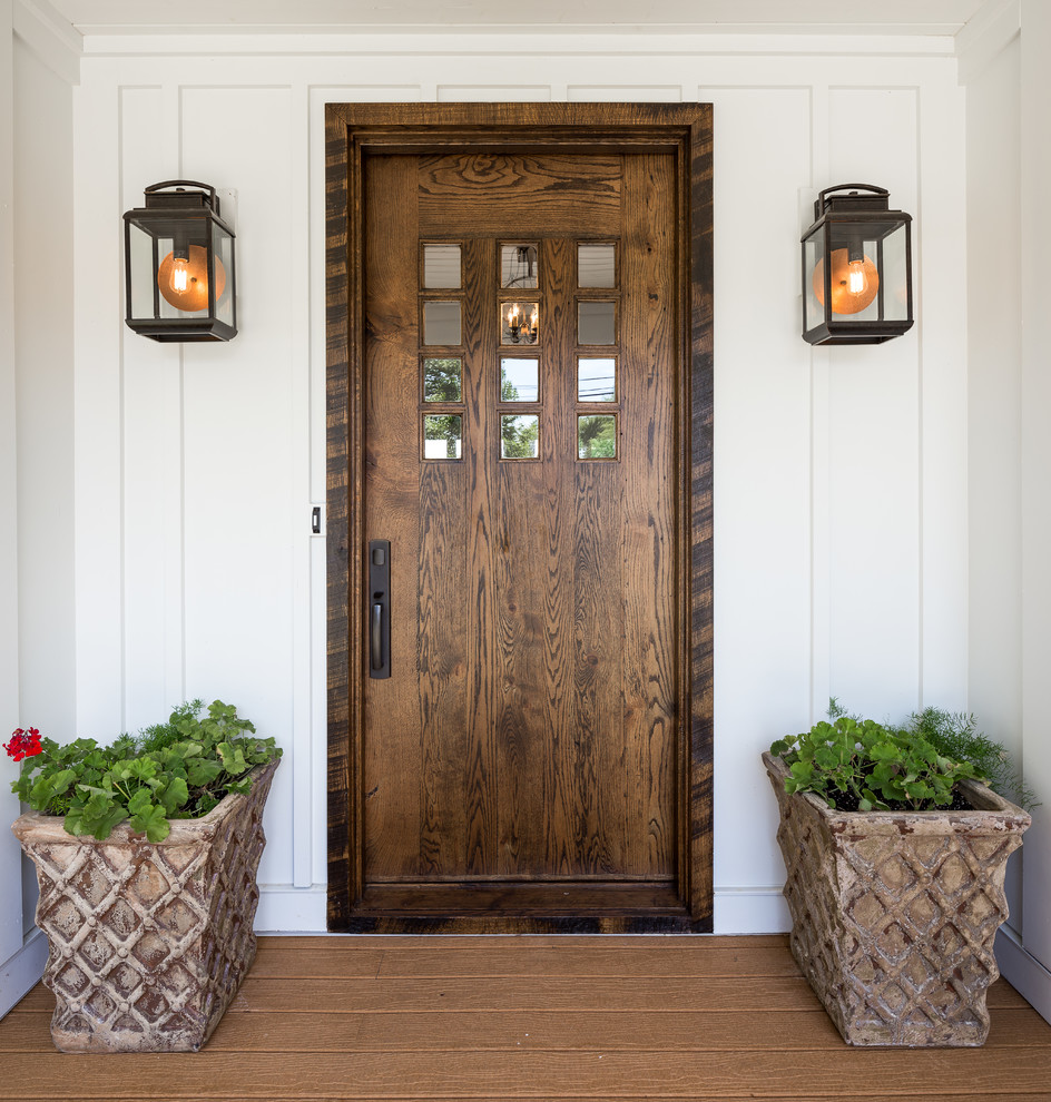 Idée de décoration pour une porte d'entrée champêtre de taille moyenne avec un mur blanc, parquet clair, une porte simple et une porte en bois foncé.