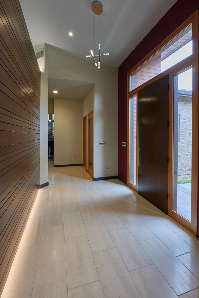 Idee per un grande ingresso minimalista con pareti multicolore, una porta singola, una porta in legno scuro, pavimento in laminato e pavimento beige